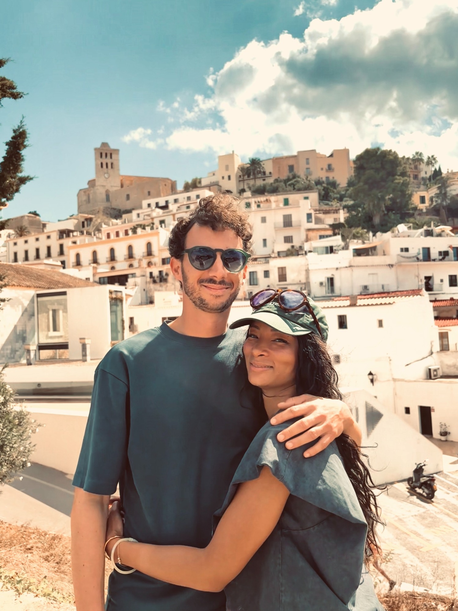 Alexandre et Karabo en voyage, devant un village ensoleillé